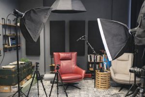 Professionell filmproduktion i studio med belysning och fåtöljer.