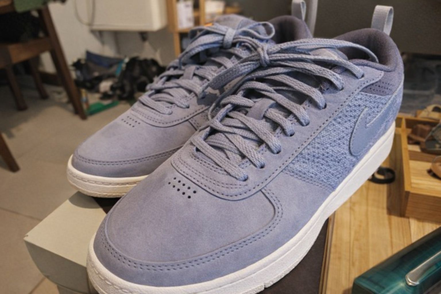 Ett par blå sneakers i mocka som representerar bekväma skor för utomhusaktiviteter.